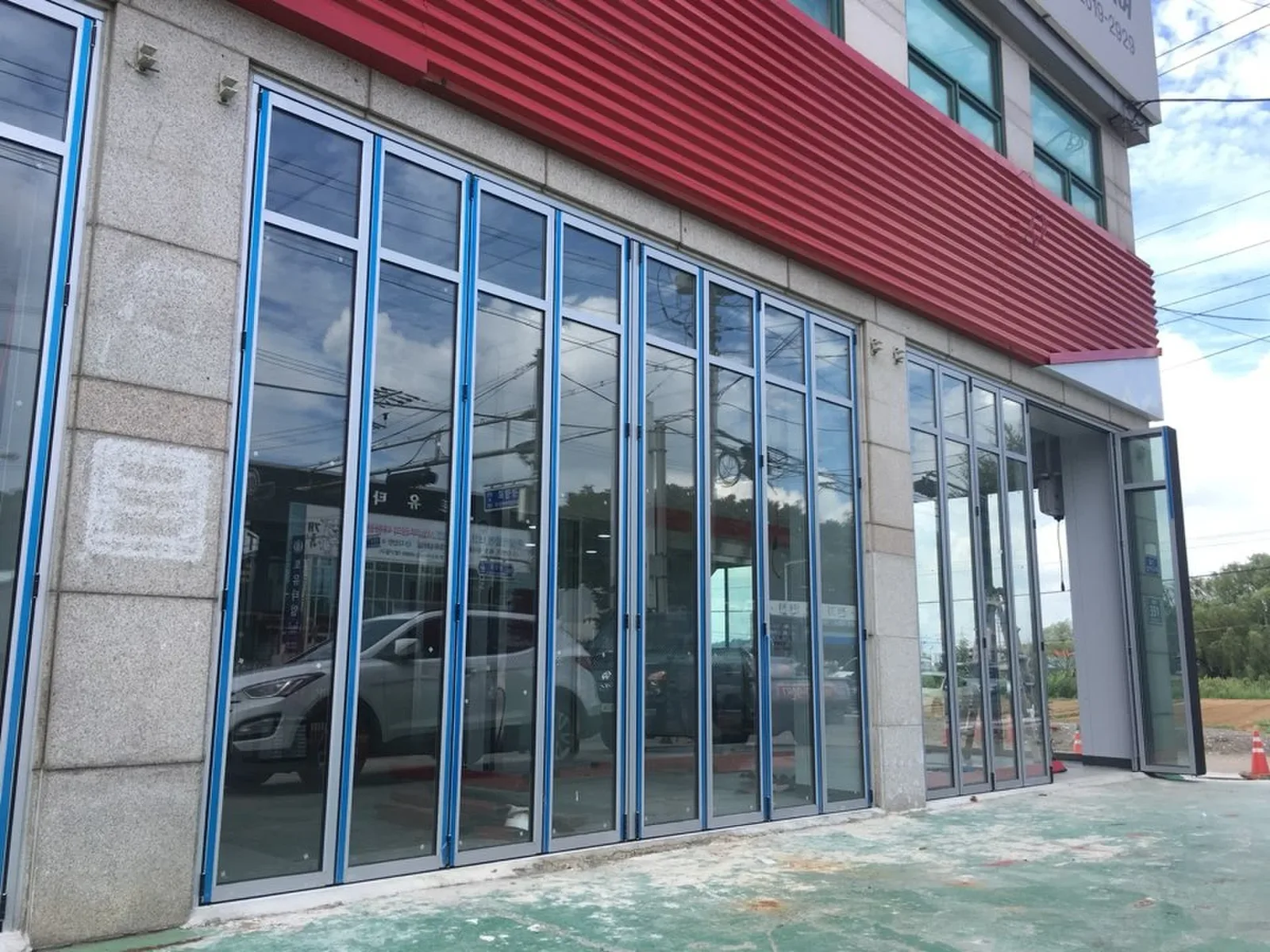 상가 전면에 시공된 블루 프레임 접이식폴딩도어 실제 현장